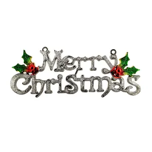 Close-up of a silver glitter Merry Christmas hanging sign with green holly leaves