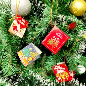 Detailansicht festlicher Mini-Weihnachtskarten, die an einem geschmückten Tannenbaum hängen