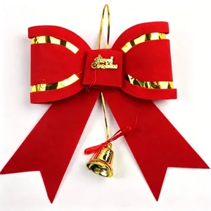 Close-up of red velvet Christmas bow with gold Merry Christmas sign and bell.