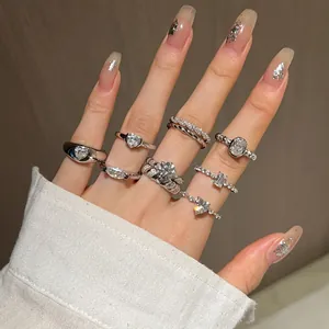 Detailed view of sterling silver rings with zircon heart and geometric designs on hand