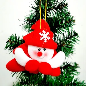 Close-up of a plush fabric Santa Claus ornament hanging on a Christmas tree branch
