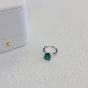 Primo piano di un elegante anello in argento S925 con zircone verde taglio smeraldo.