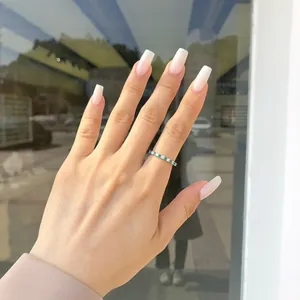Primo piano di un elegante anello in argento S925 con zirconi verdi su una mano curata