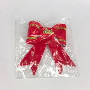 Detail of a red velvet Christmas bow ornament with Merry Christmas lettering