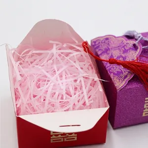 Scatole di caramelle nuziali cinesi tradizionali con carta tagliata rosa e nappe rosse