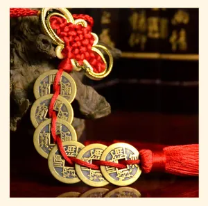 Detailed macro shot of Five Emperors Coins with red Chinese knot and silk tassel for luck