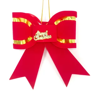 Large red velvet Christmas bow with golden Merry Christmas sign for tree decoration.