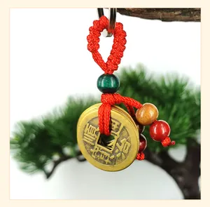 Detailed view of traditional Chinese copper coin pendant with red silk knot and colorful beads
