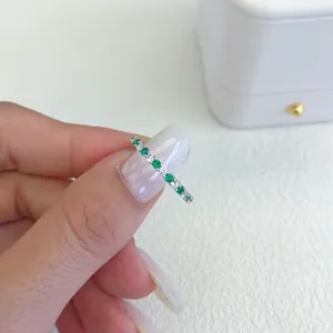 Dettaglio macro di anello in argento S925 con zirconi verdi e bianchi alternati