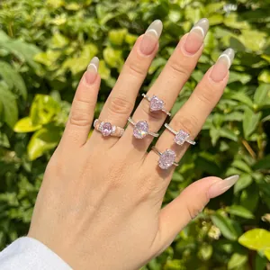 Detail of five sterling silver rings with pink ice-flower cut zircons worn on fingers.