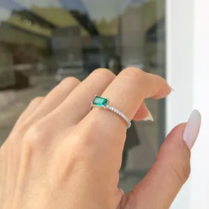 Dettaglio di un anello in zircone verde taglio smeraldo su mano, finitura argento S925.