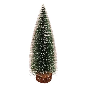 Mini green frosted Christmas tree with snow effect and natural wooden base for desk decor
