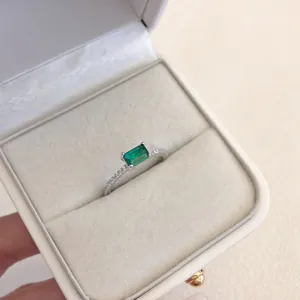 Macro dettaglio di un elegante anello in argento S925 con zircone verde smeraldo rettangolare.