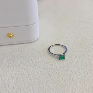 Primo piano di un anello vintage in argento S925 con uno zircone verde brillante.