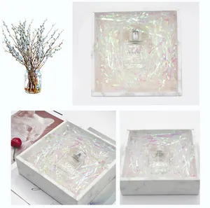 Detail showing iridescent shredded paper filler inside a luxury marble gift box