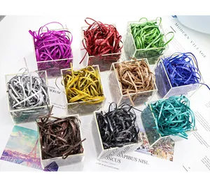 Close-up display of multiple colors of glitter raffia grass gift box filler shredded paper