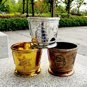 Close-up of three decorative Christmas pots in metallic gold, silver, and bronze.