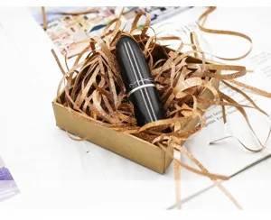 Detail view of golden glitter shredded raffia paper for luxury gift box filling