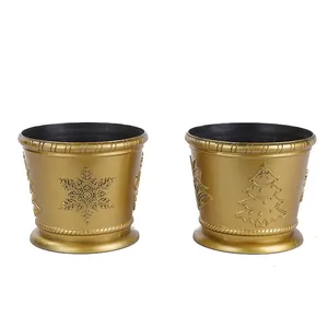 Detailed view of two gold Christmas decorative pots featuring embossed snowflake and tree patterns