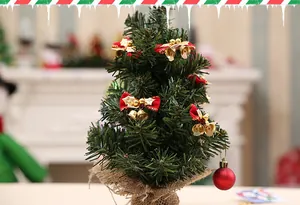 Detalle de un mini árbol de Navidad con lazos rojos y cascabeles dorados decor