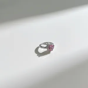 Close-up view of a sterling silver ring with a pink heart-shaped faceted zirconia stone.
