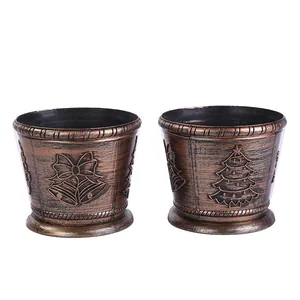 Pair of vintage bronze Christmas tree stands featuring embossed bells and tree patterns