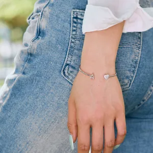 Nahaufnahme des S925 Sterling Silber Armreifs mit Herz- und Anfangsbuchstaben-Anhängern.