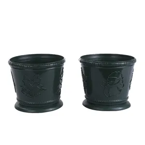 Detailed view of green Christmas themed flower pots with embossed snowman and bell patterns