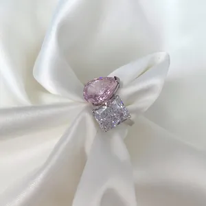 Close-up detail of pink pear and white radiant-cut ice flower zircons on silver ring