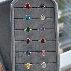 Close-up of 12 multi-colored birthstone rings with ice flower cut in a gray jewelry box