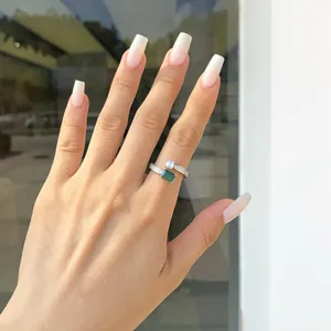 Primo piano di anello vintage in argento S925 con zircone verde smeraldo sulla mano