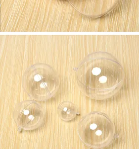 Clear hollow plastic Christmas balls in various sizes on a wood background