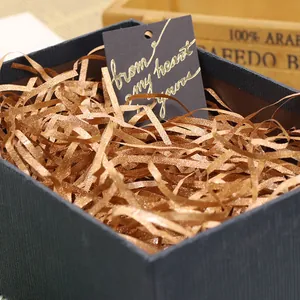 Gold glitter shredded paper filler for gift boxes, perfect for Valentine's Day and birthdays.