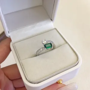 Dettaglio macro di un anello in zircone verde smeraldo in una scatola regalo bianca
