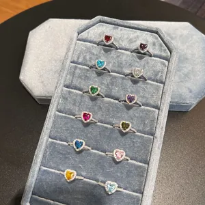 Präsentation von 12 herzförmigen Geburtssteinringen aus S925 Sterlingsilber auf Tablett.