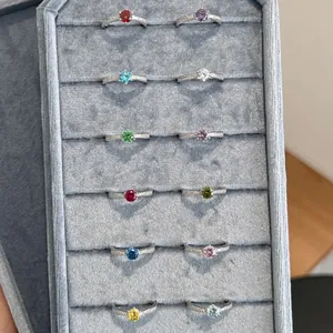 Collection of 12 S925 sterling silver birthstone rings with colorful gems in a tray