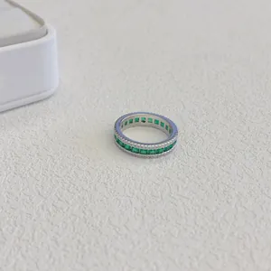 Primo piano di un anello eternity in argento con zirconi verdi quadrati e dettagli pavé