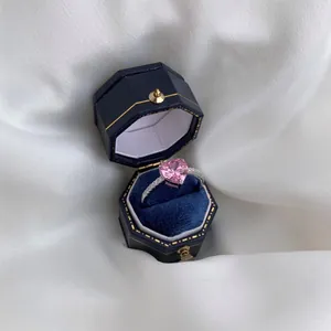 Détail d'une bague en argent S925 avec un zircon rose en forme de cœur dans un écrin bleu.