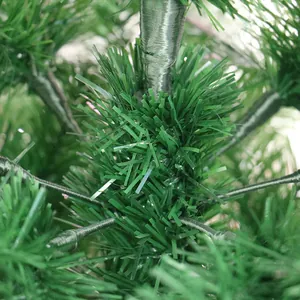 Detailaufnahme der dichten Nadeln eines grünen PVC-Weihnachtsbaums für die Weihnachtsdeko