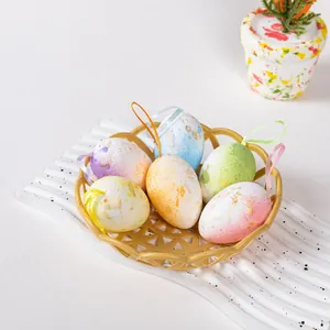 Vibrant Easter foam eggs with gold speckles and hanging loops presented in a golden basket