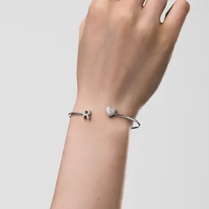 Detailansicht eines S925 Sterling Silberarmreifs mit Herz und Buchstabe R am Handgelenk.