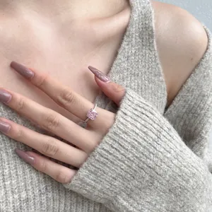 Gros plan d'une bague en argent 925 avec un zircon rose étincelant taille glace sur un mannequin.