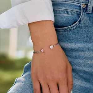 Nahaufnahme eines S925 Silberarmbands mit Herz und Buchstabe Y am Handgelenk einer Frau