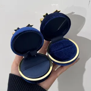 Detaillierte Ansicht von zwei runden marineblauen Schmuckschatullen aus Samt mit Goldstern