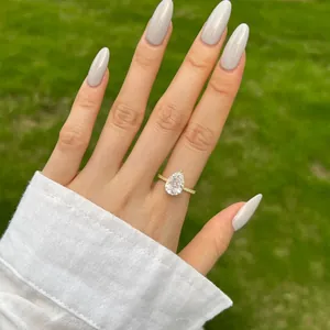 Gros plan d'une bague étincelante en argent taillée en poire sur un doigt manucuré
