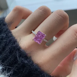 Nahaufnahme eines Rings mit rosa Edelstein im Eiskristallschliff auf einem Finger.
