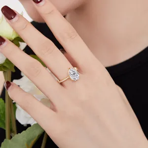 Close-up detail of a luxurious pear-cut zircon wedding ring on a finger with red nails