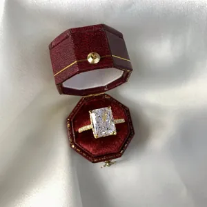 Nahaufnahme eines Smaragdschliff-Rings mit hohem Kohlenstoffgehalt in roter Schmuckschatulle
