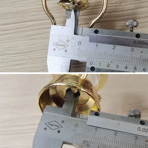Gros plan d'un pied à coulisse mesurant un accessoire de lampe dorée miniature