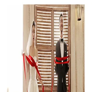 Vivace nastro in organza rossa tenuto da una coppia di sposi per dettagli decorativi